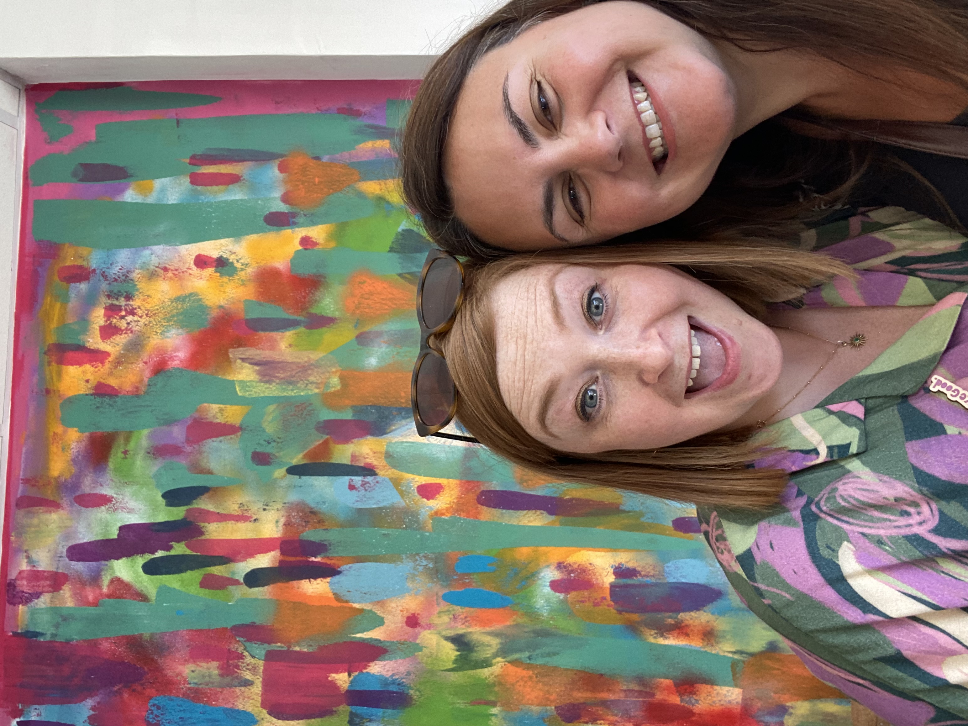 Simone, Purpose Fuelled Coach smiling with client next to colourful backdrop