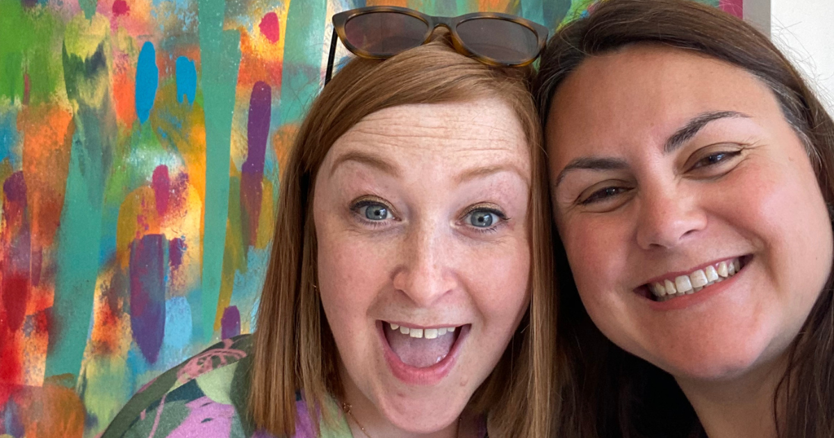 Simone, Purpose Fuelled Coach smiling with client next to colourful backdrop