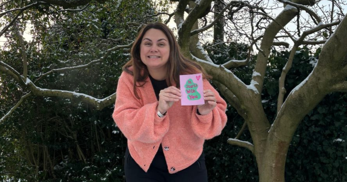 Simone Callaghan - Purpose Fuelled Coach holding up a postcard 'It Starts With You'